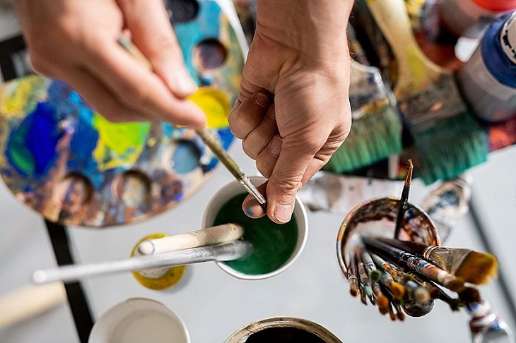 artist cleaning paintbrushes