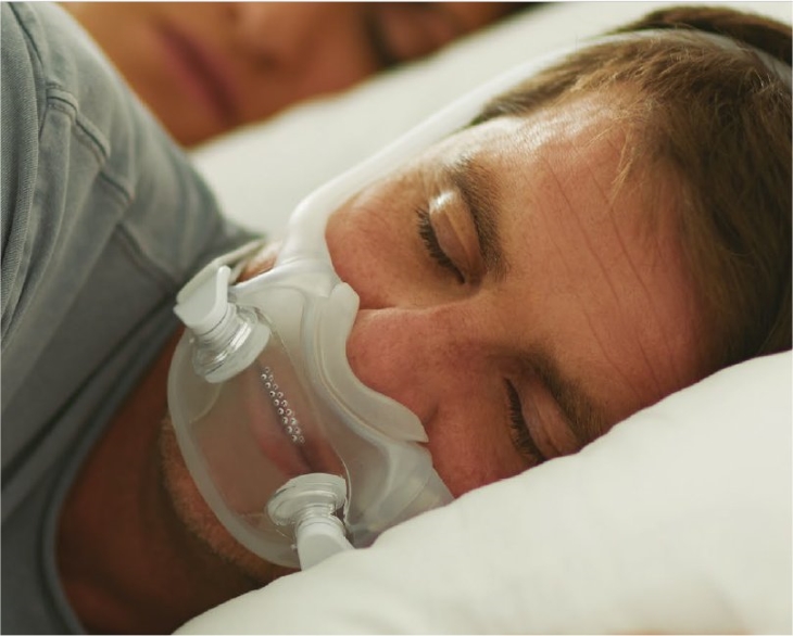 man sleeping while using cpap mask