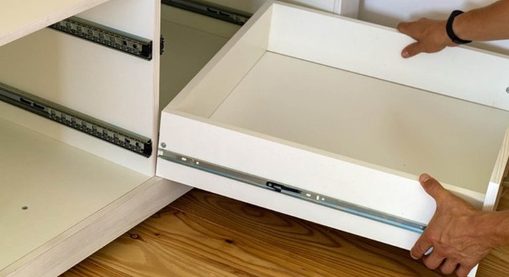 a person mounting a drawer with soft close mechanism